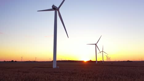 Excellent-Rising-Aerial-Of-Windmills-Generating-Clean-Electricity-On-The-Flat-Farmlands-Of-Indiana,-Illinois,-At-Dawn-Or-Sunset