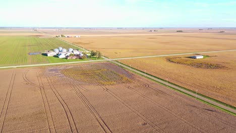 Good-Aerial-Over-An-Intersection-In-Two-Roads-In-The-Middle-Of-Nowhere-Vast-Flat-Farmland-And-Fields-In-Iowa,-Illinois,-Or-Indiana