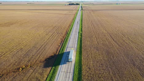 Excelente-Antena-De-Un-Camión-Solitario-Que-Viaja-Por-Una-Carretera-Solitaria-En-Las-Tierras-De-Cultivo-Del-Medio-Oeste,-Illinois,-Indiana-O-Iowa