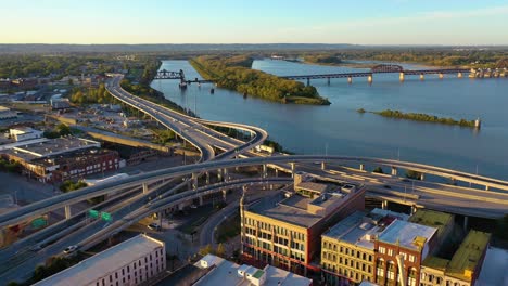 Aerial-Over-Freeway-Interchange-In-Louisville,-Kentucky-With-Ohio-River-Background-Suggests-Infrastructure