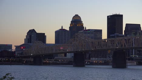 Good-Dusk-Establishing-Shot-Of-Louisville,-Kentucky-Downtown-Skyline,-With-George-Rogers-Clark-Memorial-Bridge-In-Foreground