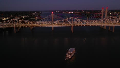 Night-Aerial-Of-Bridges-And-Paddlewheel-Boat-On-The-Ohio-River-At-Jeffersonville,-Indiana-And-Louisville,-Kentucky