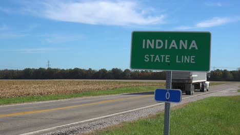 Sign-Indicates-The-Indiana-State-Line-As-A-Truck-Passes-On-A-Rural-Road