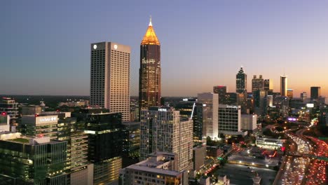 Panning-Aerial-Shot-Of-Atlanta,-Georgia-Freeway-And-Downtown-Skyline-At-Dusk,-Sunset-Or-Night