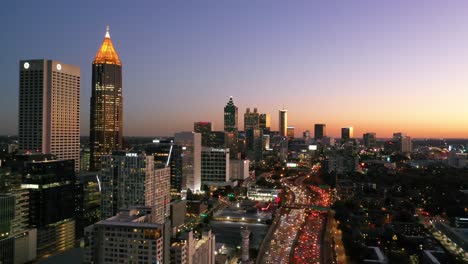 Panning-Aerial-Shot-Of-Atlanta,-Georgia-Freeway-And-Downtown-Skyline-At-Dusk,-Sunset-Or-Night