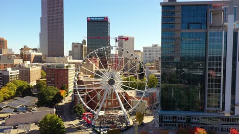 Aerial-Of-Ferris-Wheel-Reveals-Olympic-Park-In-Downtown-Atlanta,-Georgia-And-City-Skyline