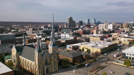 Aerial-Past-A-Church-With-The-Skyline-Of-Grand-Rapids,-Michigan-In-The-Background