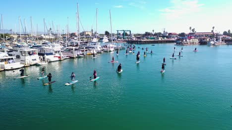 Aerial-Witches-Paddle-On-Surfboards-And-Paddleboards-To-Celebrate-Halloween-In-Ventura-Harbor,-California