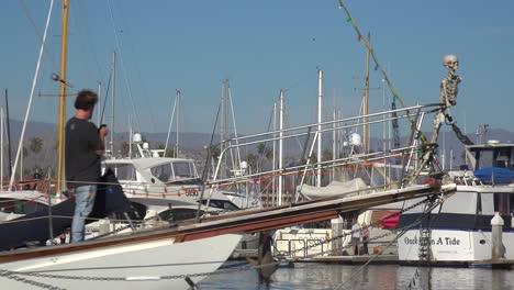 Ein-Halloween-Partyboot-Mit-Einem-Skelett-Am-Bug-Und-Einem-Großen-Orangefarbenen-Kürbis-Am-Heck-Bewegt-Sich-Durch-Den-Hafen-Von-Ventura,-Kalifornien