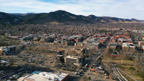 Antena-Del-Centro-De-La-Ciudad-De-Boulder,-Colorado-Y-Suburbios-Con-Rango-Frontal-De-Las-Montañas-Rocosas-En-El-Fondo,-Invierno