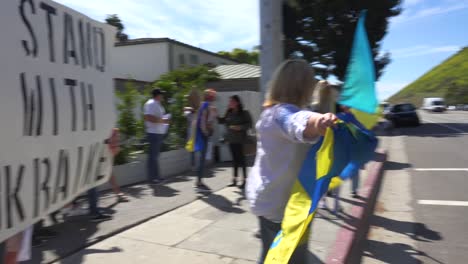 Eine-Ukrainische-Antikriegs-Demonstrantin-Schwenkt-Eine-Fahne-Auf-Dem-Pier-Von-Malibu,-Um-Gegen-Die-Russische-Invasion-In-Der-Ukraine-Zu-Protestieren
