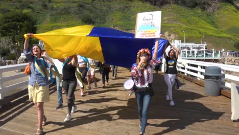 Ukrainische-Antikriegs-Demonstranten-Aus-Der-Luft-Zeigen-Flaggen-Und-Schilder-Auf-Dem-Pacific-Coast-Highway-PCH-Malibu,-Kalifornien,-Um-Gegen-Die-Russische-Invasion-In-Der-Ukraine-Zu-Protestieren