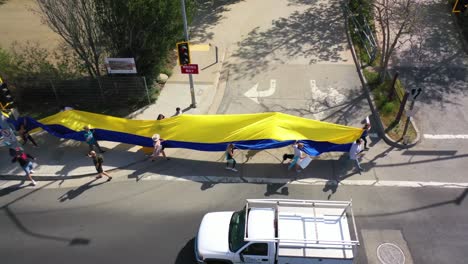 Ukrainische-Antikriegs-Demonstranten-Aus-Der-Luft-Zeigen-Eine-Lange-Flagge-Und-Schilder-Auf-Dem-Pacific-Coast-Highway-PCH-Malibu,-Kalifornien,-Um-Gegen-Die-Russische-Invasion-In-Der-Ukraine-Zu-Protestieren