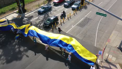 Ukrainische-Antikriegs-Demonstranten-Aus-Der-Luft-Zeigen-Flaggen-Und-Schilder-In-Malibu,-Kalifornien,-Um-Gegen-Die-Russische-Invasion-In-Der-Ukraine-Zu-Protestieren