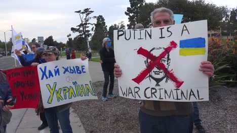 Putin-Ist-Ein-Kriegsverbrecherzeichen,-Das-Von-Ukrainischen-Demonstranten-Gehalten-Wird,-Nachdem-Russland-In-Die-Ukraine-Einmarschiert-Ist