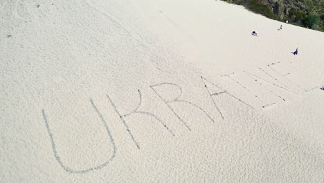 Aerial-Of-The-Word-Ukraine-Written-On-Sand-Dunes-At-Pt-Magu-Near-Malibu,-California