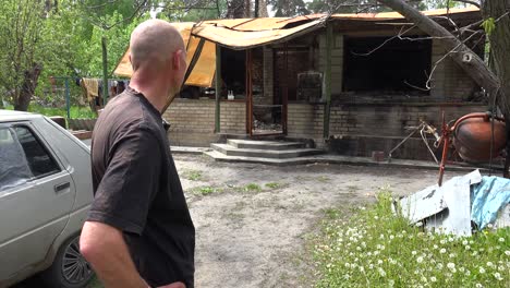 Ein-Mann-Betrachtet-Die-Ausgebrannten-Und-Zerstörten-überreste-Seines-Hauses-Nach-Dem-Russischen-Beschuss-In-Irpin,-Ukraine