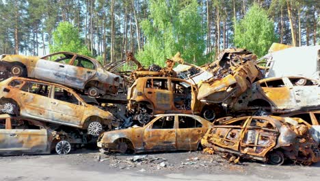 Rising-Aerial-Of-Wrecked-And-Burned-Cars-In-The-Car-Cemetery-Sitting-In-A-Pile-Many-With-Bullet-Holes-From-Russian-Aggression,-Irpin-Ukraine