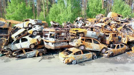 Rising-Aerial-Of-Wrecked-And-Burned-Cars-In-The-Car-Cemetery-Sitting-In-A-Pile-Many-With-Bullet-Holes-From-Russian-Aggression,-Irpin-Ukraine