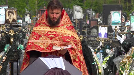 A-Ukrainian-Orthodox-Priest-Administers-Last-Rites-To-A-Victim-Of-The-War-In-Ukraine,-In-The-Irpin-(Kyiv)-Cemetery