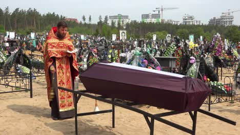 A-Ukrainian-Orthodox-Priest-Administers-Last-Rites-To-A-Victim-Of-The-War-In-Ukraine,-In-The-Irpin-(Kyiv)-Cemetery