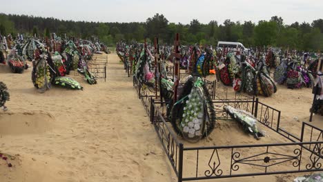 Ein-Schwenk-über-Den-Friedhof-Zeigt-Einen-Ukrainisch-orthodoxen-Priester,-Der-Einem-Opfer-Des-Krieges-In-Der-Ukraine-Auf-Dem-Friedhof-Von-Irpin-(Kiew)-Die-Letzte-Ölung-Spendet