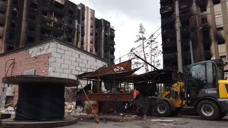 Männer-Schaufeln-Die-Verbrannten-Überreste-Von-Gebäuden-Nach-Einem-Russischen-Raketenangriff-In-Irpin,-Ukraine