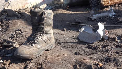 A-Russian-Boot-Sits-On-The-Battlefield-With-Shrapnel-Nearby,-Donbas,-Ukraine