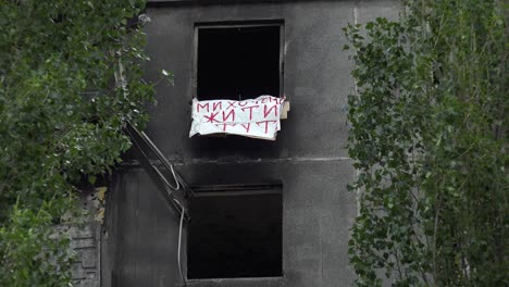 Un-Cartel-En-La-Ventana-De-Un-Edificio-De-Apartamentos-Quemado-Y-Destruido-En-Ucrania-Dice-&quot;queremos-Vivir&quot;