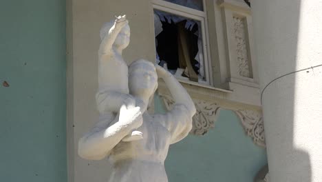 Statues-Stand-In-Front-Of-The-Devastated-Exterior-Of-The-Bucha-Concert-Music-Hall-In-Bucha,-Ukraine-Following-The-Russian-Invasion