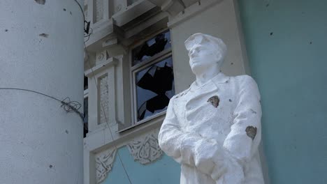 Statues-Stand-In-Front-Of-The-Devastated-Exterior-Of-The-Bucha-Concert-Music-Hall-In-Bucha,-Ukraine-Following-The-Russian-Invasion
