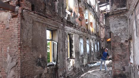 Un-Trabajador-Desaloja-Un-Viejo-Radiador-De-Un-Edificio-Escolar-Que-Ha-Sido-Destruido-Por-Un-Ataque-Con-Cohetes-Rusos-En-Saltivka,-Kharkiv,-Ucrania