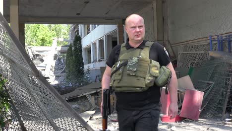Ein-Ukrainischer-Polizist-Geht-Durch-Eine-Durch-Russische-Raketen-Zerstörte-Mittelschule-In-Charkiw,-Ukraine