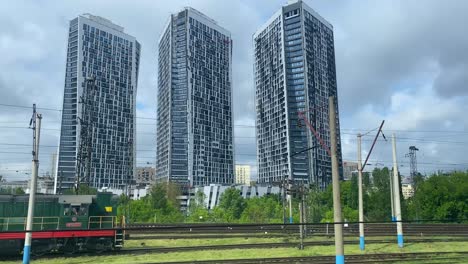 Toma-Pov-De-Un-Tren-Que-Ingresa-A-Kiev-Kyiv-Ucrania-Con-Modernos-Apartamentos-De-Gran-Altura-Visibles