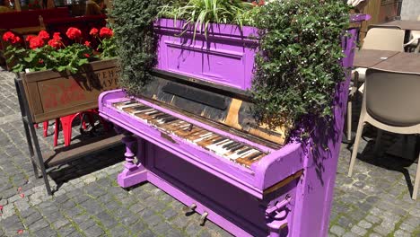 Un-Viejo-Piano-Morado-Desgastado-Se-Encuentra-Afuera-En-Un-Café-En-Lviv,-Ucrania