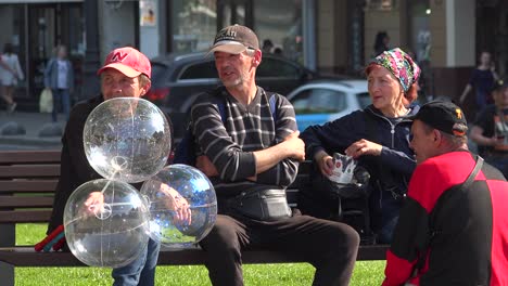 Ukrainians-Sit-On-A-Park-Bench-Enjoying-The-Sunshine-In-Central-Lviv,-Ukraine