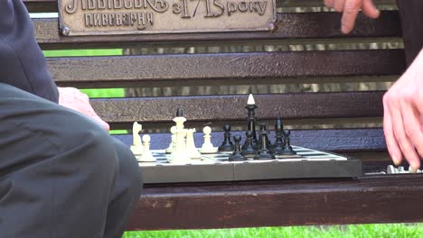 Two-Old-Men-Play-Chess-On-A-Bench-In-The-Park-In-Central-Lviv,-Ukraine