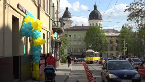 Gute-Einspielung-Von-Lemberg,-Ukraine,-Mit-Trolley,-Straße,-Alten-Gebäuden-Und-Patriotischen-Luftballons