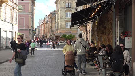 Good-Establishing-Shot-Of-Old-City-Lviv,-Ukraine,-With-Cafe,-Street,-Old-Buildings-And-Pedestrians