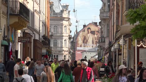 Good-Establishing-Shot-Of-Crowds-In-Old-City-Lviv,-Ukraine,-With-Cafe,-Street,-Old-Buildings-And-Pedestrians