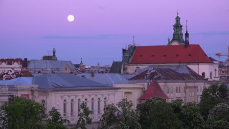 Hermosa-Luna-Llena-Sobre-Los-Tejados-Y-Edificios-Clásicos-En-El-Centro-De-Lviv,-Ucrania