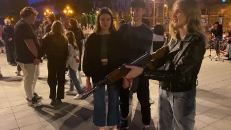 Young-Girl-Shoots-An-Air-Rifle-At-The-Image-Of-Vladmir-Putin-On-The-Street-In-Central-Lviv,-Ukraine