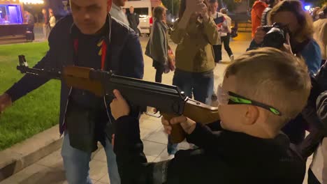 Young-Boy-Shoots-An-Air-Rifle-At-The-Image-Of-Vladmir-Putin-On-The-Street-In-Central-Lviv,-Ukraine