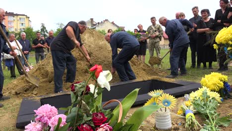 Los-Trabajadores-Palean-La-Suciedad-Fresca-En-Una-Tumba-Abierta-En-Un-Cementerio-En-Lviv,-Ucrania-Durante-Un-Funeral-De-Entierro-De-Un-Soldado-De-Guerra-Ucraniano