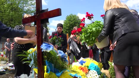 A-Family-Places-Flowers-On-The-Grave-Of-A-Fallen-Ukrainian-Soldier-During-The-War-In-Ukraine