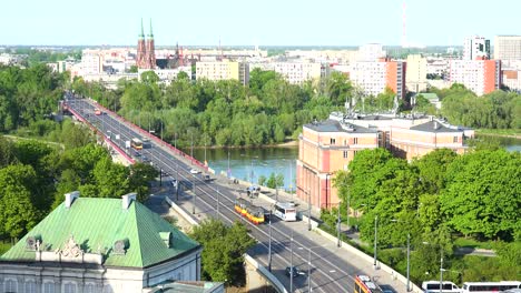Establishing-Shot-Of-Suburbs-Of-Warsaw-Poland,-With-Trolleys-And-Busses-Over-The-Śląsko-Dąbrowski-Bridge-And-Vistula-River