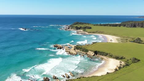 An-Excellent-Aerial-Shot-Of-Waves-Lapping-The-Shores-Of-Narooma-Beach-In-New-South-Wales,-Australia