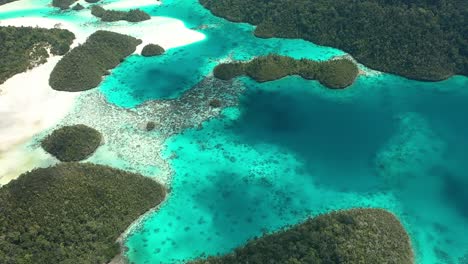 Ausgezeichnete-Luftaufnahme-Der-Wayag-inseln,-Raja-Ampat,-Indonesien,-Mit-Den-Schatten-Vorbeiziehender-Wolken,-Die-Im-Klaren-Blauen-Wasser-Sichtbar-Sind