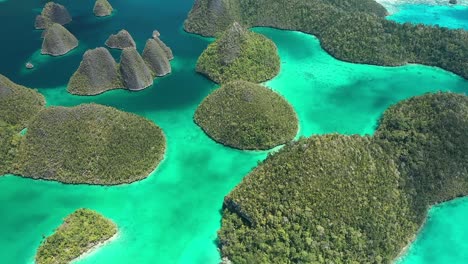 Excelente-Toma-Aérea-De-Las-Islas-Wayag,-Raja-Ampat,-Indonesia,-Con-Las-Sombras-De-Las-Nubes-Que-Pasan-Visibles-En-El-Agua-Azul-Clara