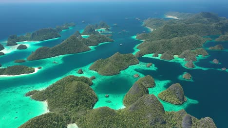 Excellent-Aerial-Shot-Of-The-Wayag-Islands,-Raja-Ampat,-Indonesia,-With-The-Shadows-Of-Passing-Clouds-Visible-In-The-Clear-Blue-Water